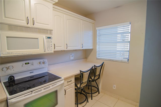 9420 Poinciana Pl Unit 115, Davie, FL 33324 - kitchen featuring white appliances, built in desk, light tile patterned flooring, white cabinetry, and light countertops