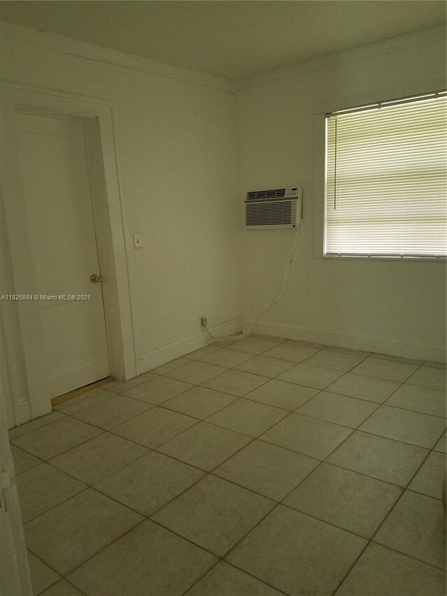 559 NW 44th St, Miami, FL 33127 - spare room featuring a wall unit AC, light tile patterned flooring, and ornamental molding