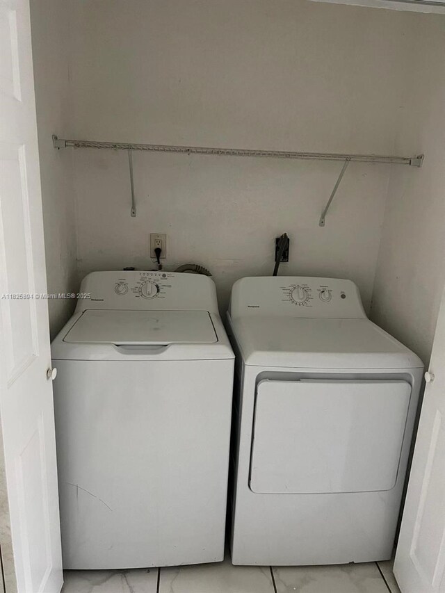 559 NW 44th St, Miami, FL 33127 - laundry area with separate washer and dryer and light marble finish flooring