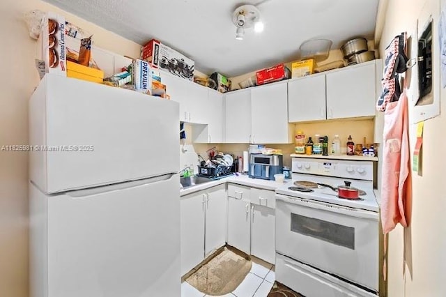 301 NW 177th St Unit 227, Miami Gardens, FL 33169 - kitchen with white appliances, light countertops, white cabinetry, and light tile patterned floors
