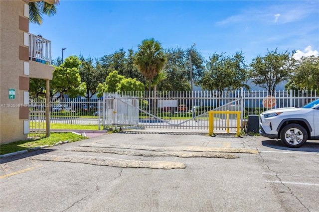 301 NW 177th St Unit 227, Miami Gardens, FL 33169 - view of asphalt street featuring a gate, street lighting, and a gated entry