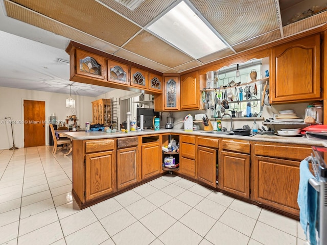 17430 SW 92nd Ct, Palmetto Bay, FL 33157 - kitchen featuring brown cabinetry, light countertops, a peninsula, and glass insert cabinets