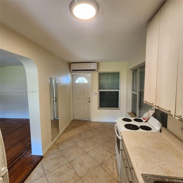1843 Wiley St, Hollywood, FL 33020 - entrance foyer with a wall mounted air conditioner, arched walkways, and light tile patterned flooring