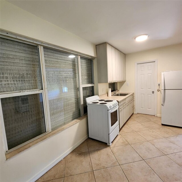 1843 Wiley St, Hollywood, FL 33020 - kitchen featuring white appliances, light tile patterned floors, and light countertops