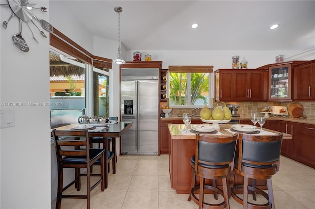 14241 SW 30th St, Miami, FL 33175 - kitchen with stainless steel built in fridge, decorative backsplash, glass insert cabinets, a center island, and light tile patterned flooring