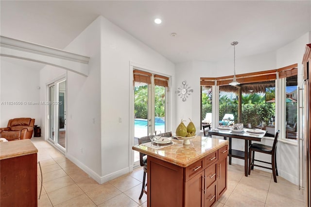 14241 SW 30th St, Miami, FL 33175 - kitchen featuring light tile patterned floors, decorative light fixtures, recessed lighting, a center island, and light stone counters