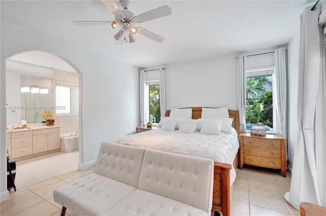 14241 SW 30th St, Miami, FL 33175 - bedroom with light tile patterned floors, multiple windows, arched walkways, and ensuite bathroom