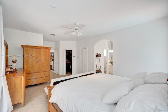 14241 SW 30th St, Miami, FL 33175 - bedroom with arched walkways, light tile patterned flooring, a ceiling fan, ensuite bath, and a closet
