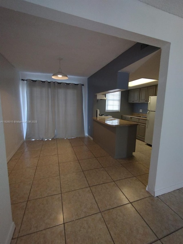 2775 L B Mcleod St Unit B, Orlando, FL 32805 - kitchen with freestanding refrigerator, light tile patterned floors, a peninsula, and pendant lighting