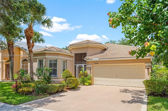 7348 Copperfield Cir, Lake Worth, FL 33467 - mediterranean / spanish house with a tiled roof, an attached garage, driveway, and stucco siding