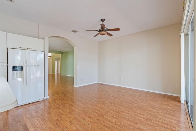 7348 Copperfield Cir, Lake Worth, FL 33467 - empty room featuring ceiling fan, arched walkways, and light wood-type flooring
