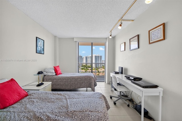 3701 N Country Club Dr Unit 2209, Aventura, FL 33180 - bedroom featuring tile patterned flooring, a desk, a textured ceiling, a city view, and track lighting
