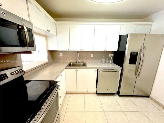 7900 Camino Cir Unit 305, Miami, FL 33143 - kitchen featuring stainless steel appliances, light countertops, light tile patterned flooring, and white cabinetry