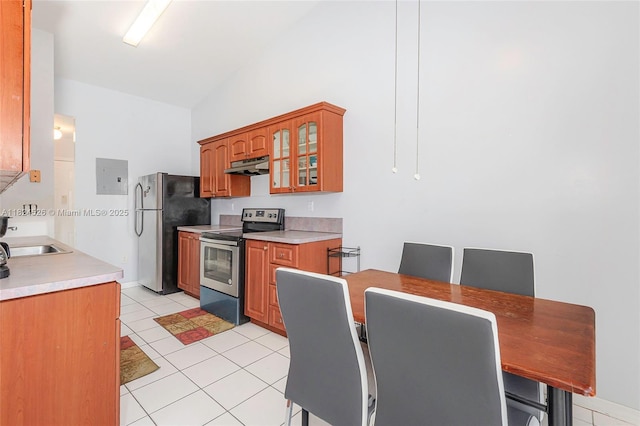 806 NE 214th Ln Unit 806-03, Miami, FL 33179 - kitchen with stainless steel appliances, under cabinet range hood, glass insert cabinets, light tile patterned flooring, and brown cabinets