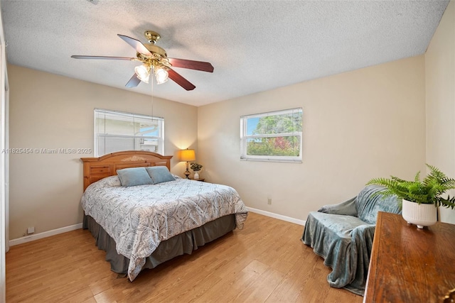 6905 NW 73rd St, Tamarac, FL 33321 - bedroom with multiple windows, light wood finished floors, a textured ceiling, and a ceiling fan