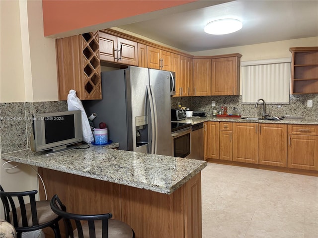 1635 W 44th Pl Unit 509, Hialeah, FL 33012 - kitchen with a peninsula, tasteful backsplash, appliances with stainless steel finishes, and a breakfast bar