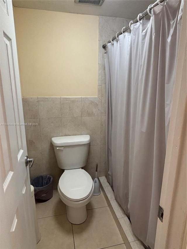1635 W 44th Pl Unit 509, Hialeah, FL 33012 - bathroom featuring tile walls, a shower with shower curtain, tile patterned flooring, and a wainscoted wall