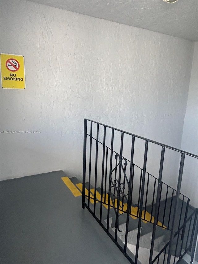 1635 W 44th Pl Unit 509, Hialeah, FL 33012 - stairway with a textured wall, concrete flooring, and a textured ceiling