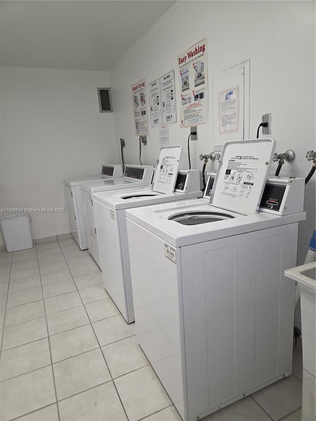 7135 Collins Ave Unit 424, Miami Beach, FL 33141 - shared laundry featuring separate washer and dryer and light tile patterned floors