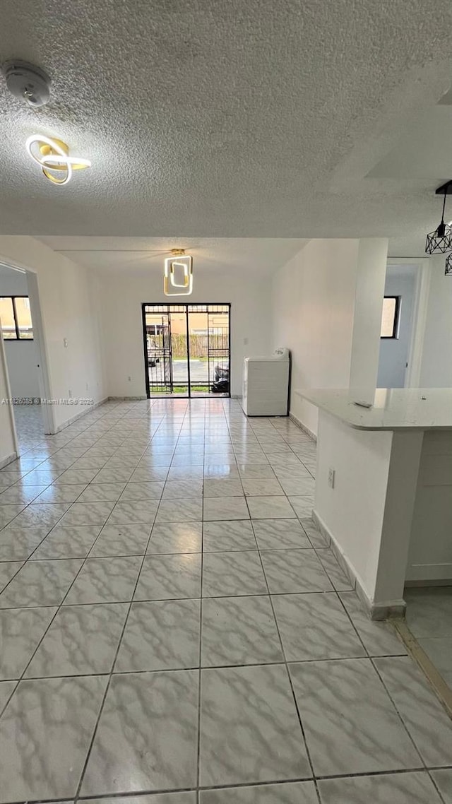 8095 NW 8th St Unit 103, Miami, FL 33126 - empty room featuring a textured ceiling and washer / dryer