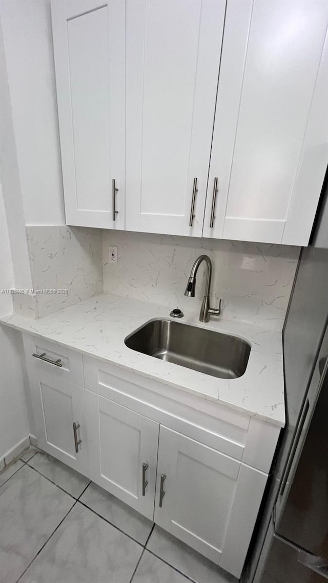 8095 NW 8th St Unit 103, Miami, FL 33126 - kitchen featuring white cabinetry, light stone counters, and tasteful backsplash