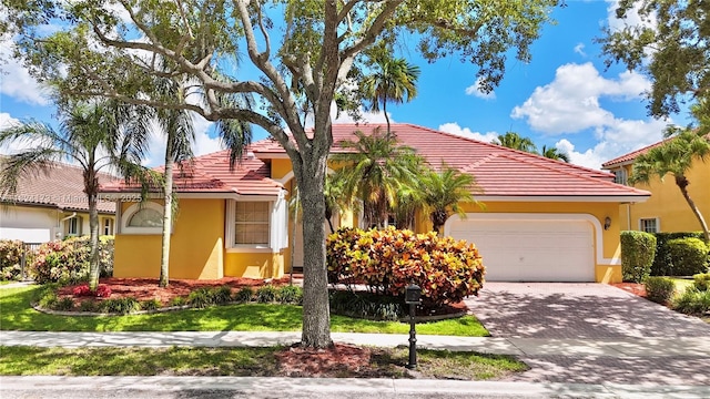 2694 Oakbrook Dr, Weston, FL 33332 - view of front of property with a garage, decorative driveway, stucco siding, and a tile roof