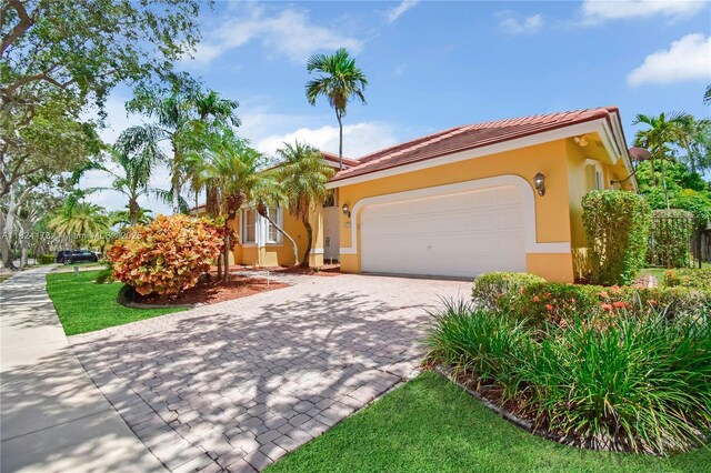 2694 Oakbrook Dr, Weston, FL 33332 - view of front of home with an attached garage, decorative driveway, stucco siding, and a tiled roof