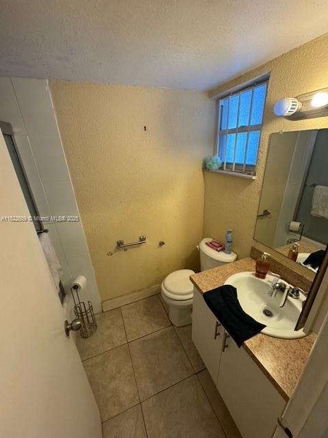 8841 W Flagler St Unit 108, Miami, FL 33174 - bathroom featuring a textured wall, a textured ceiling, vanity, and tile patterned floors