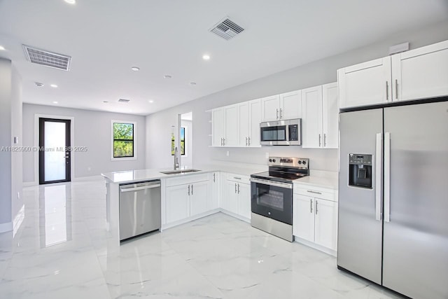 817/819 Eisenhower Blvd, Lehigh Acres, FL 33974 - kitchen with appliances with stainless steel finishes, light marble finish floors, white cabinetry, a peninsula, and light countertops