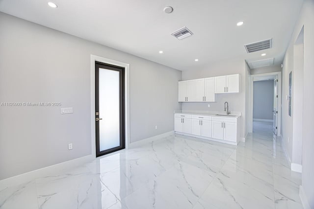 817/819 Eisenhower Blvd, Lehigh Acres, FL 33974 - kitchen featuring white cabinetry, recessed lighting, light countertops, and light marble finish floors