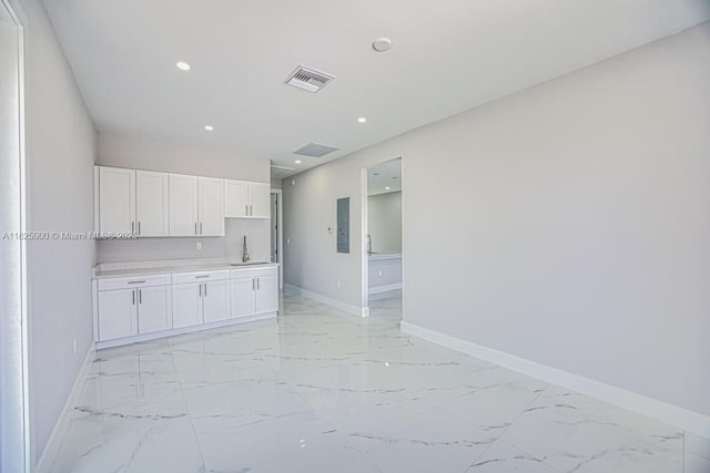 817/819 Eisenhower Blvd, Lehigh Acres, FL 33974 - kitchen featuring light marble finish flooring, white cabinetry, recessed lighting, light countertops, and electric panel