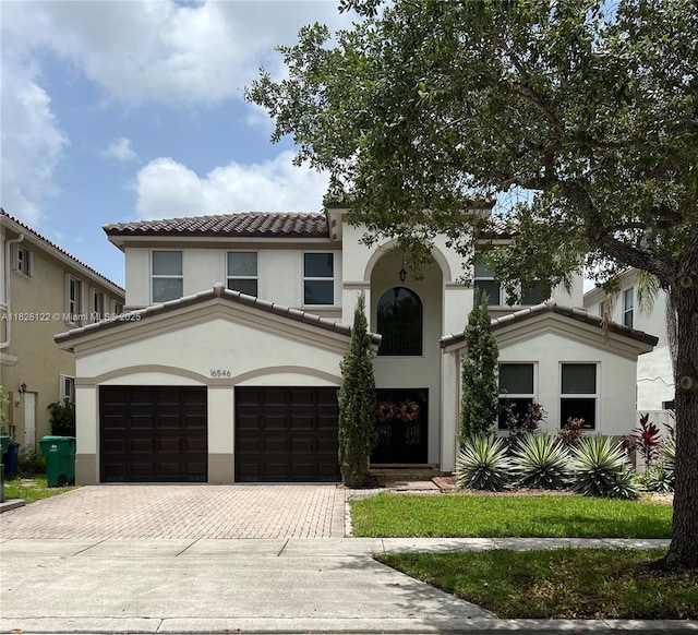 16546 SW 39th St, Miramar, FL 33027 - mediterranean / spanish house featuring decorative driveway, an attached garage, stucco siding, and a tile roof