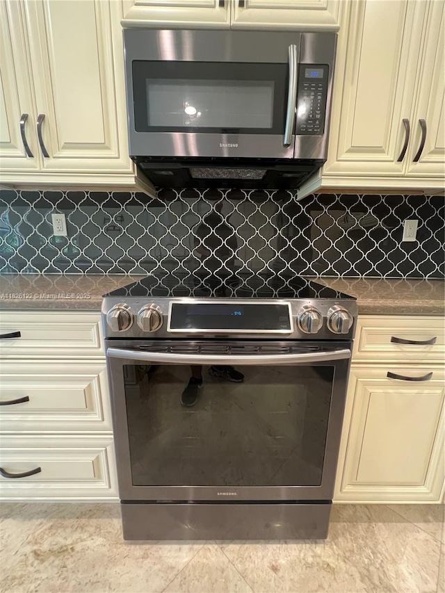 16546 SW 39th St, Miramar, FL 33027 - kitchen with appliances with stainless steel finishes, cream cabinetry, dark countertops, and backsplash
