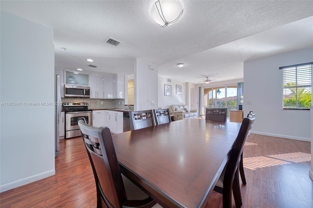 6440 NW 114th Ave Unit 434, Doral, FL 33178 - dining area with a textured ceiling, wood finished floors, and ceiling fan