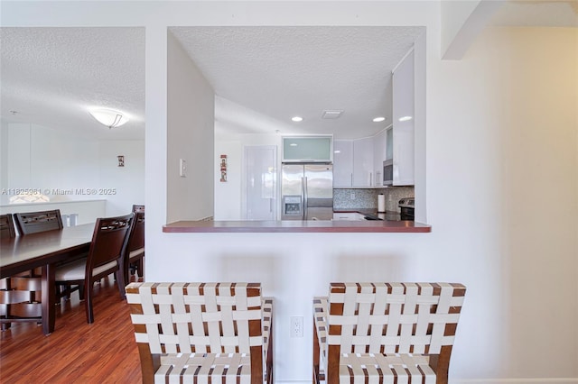 6440 NW 114th Ave Unit 434, Doral, FL 33178 - kitchen with appliances with stainless steel finishes, a textured ceiling, wood finished floors, tasteful backsplash, and recessed lighting
