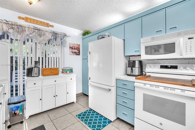 4552 Carambola Cir S Unit 27247, Coconut Creek, FL 33066 - kitchen featuring white appliances, blue cabinetry, light countertops, a textured ceiling, and light tile patterned floors