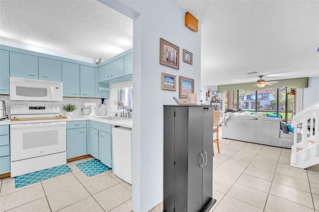 4552 Carambola Cir S Unit 27247, Coconut Creek, FL 33066 - kitchen with white appliances, a textured ceiling, blue cabinetry, ceiling fan, and light countertops