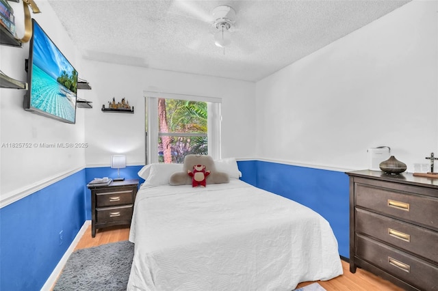 4552 Carambola Cir S Unit 27247, Coconut Creek, FL 33066 - bedroom featuring a textured ceiling, wood finished floors, and a ceiling fan