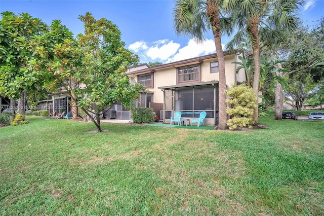 4552 Carambola Cir S Unit 27247, Coconut Creek, FL 33066 - rear view of property with stucco siding, a sunroom, and a yard