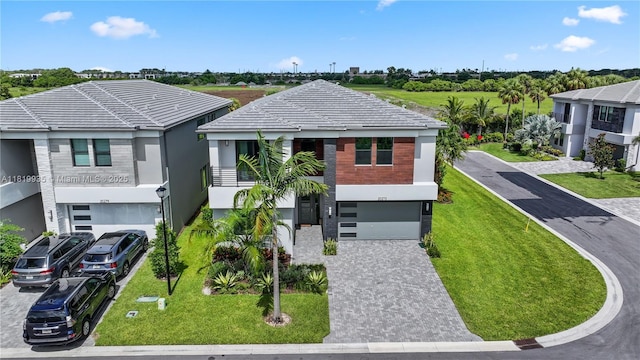 20273 Bandon Dunes Rd, Boca Raton, FL 33434 - view of front of home featuring an attached garage, driveway, stucco siding, a front lawn, and a tiled roof