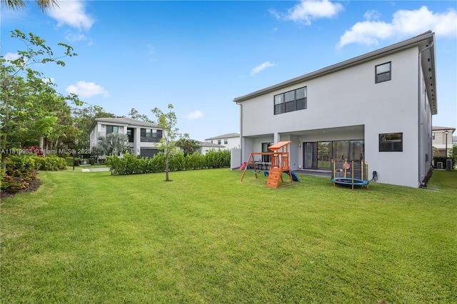 20273 Bandon Dunes Rd, Boca Raton, FL 33434 - view of grassy yard with a playground and a trampoline
