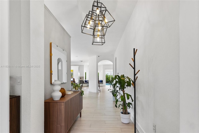 10989 NW 73rd Ter, Doral, FL 33178 - corridor with arched walkways, light wood-style floors, and a chandelier