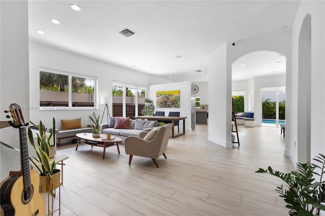 10989 NW 73rd Ter, Doral, FL 33178 - living room with arched walkways, recessed lighting, and light wood finished floors