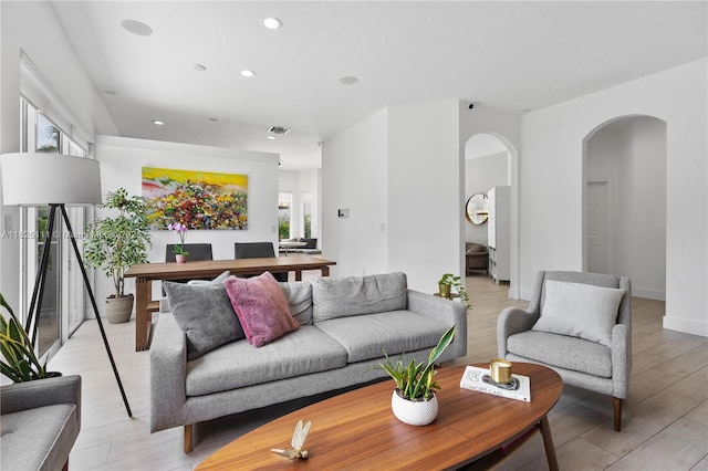 10989 NW 73rd Ter, Doral, FL 33178 - living area with arched walkways, recessed lighting, and light wood-style floors