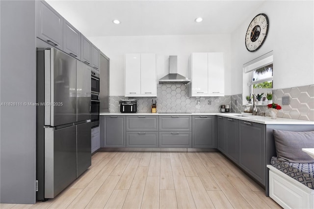 10989 NW 73rd Ter, Doral, FL 33178 - kitchen featuring wall chimney range hood, freestanding refrigerator, gray cabinets, backsplash, and light countertops