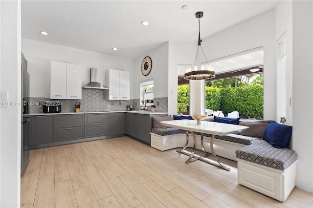 10989 NW 73rd Ter, Doral, FL 33178 - kitchen featuring wall chimney exhaust hood, breakfast area, gray cabinets, healthy amount of natural light, and recessed lighting