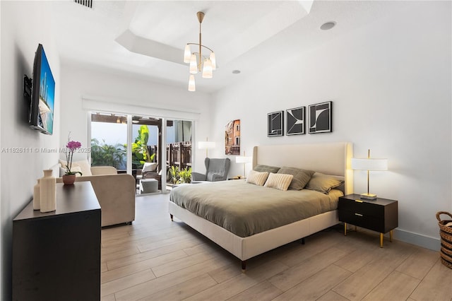 10989 NW 73rd Ter, Doral, FL 33178 - bedroom featuring access to exterior, light wood-type flooring, and a tray ceiling