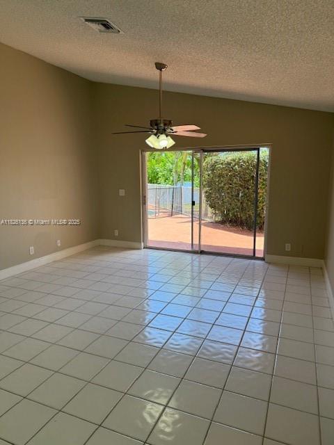 7964 La Rose Ct, Lake Worth, FL 33467 - unfurnished room featuring a textured ceiling, a ceiling fan, lofted ceiling, and light tile patterned floors