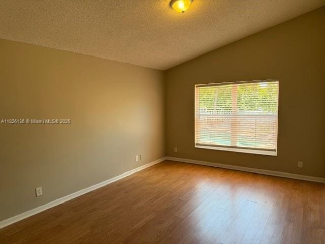 7964 La Rose Ct, Lake Worth, FL 33467 - unfurnished room with a textured ceiling, lofted ceiling, and wood finished floors