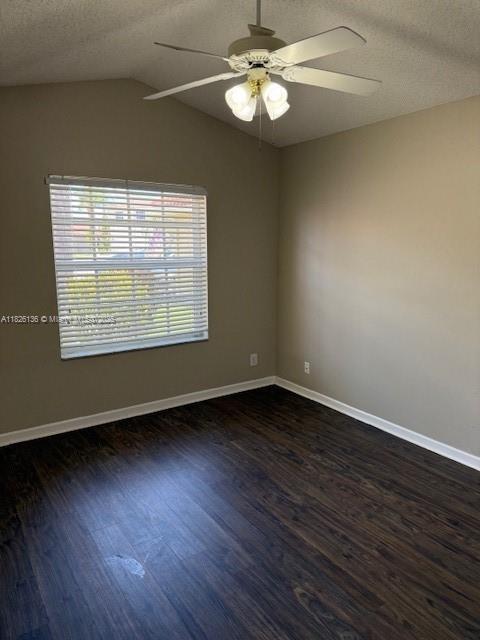 7964 La Rose Ct, Lake Worth, FL 33467 - spare room featuring a ceiling fan, a textured ceiling, dark wood finished floors, and lofted ceiling